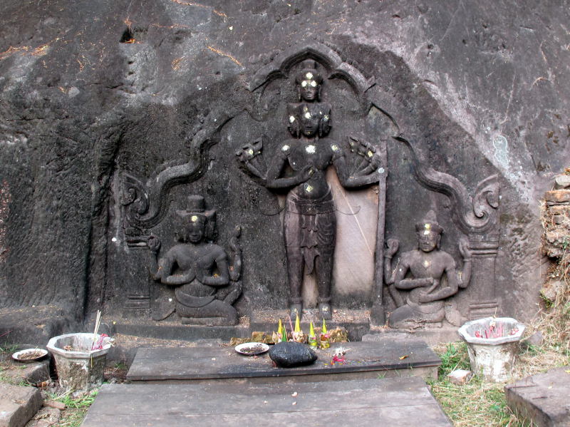 Brahma and two supplicants carved into the cliff wall